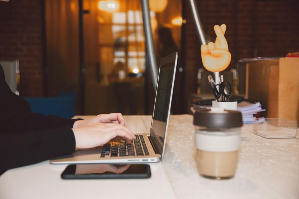 Person typing on laptop with coffee cup, symbolizing freelance virtual assistant support for solopreneurs.